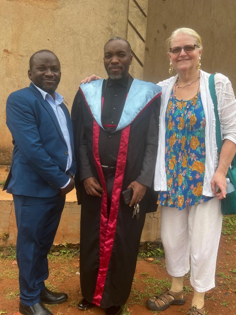 Graduate standing between two supporters after a ceremony